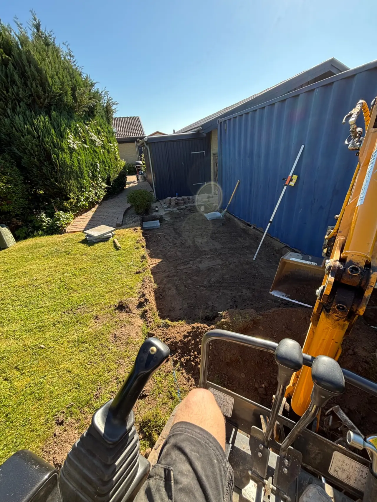Gravemaskine graver plads ud til container i have